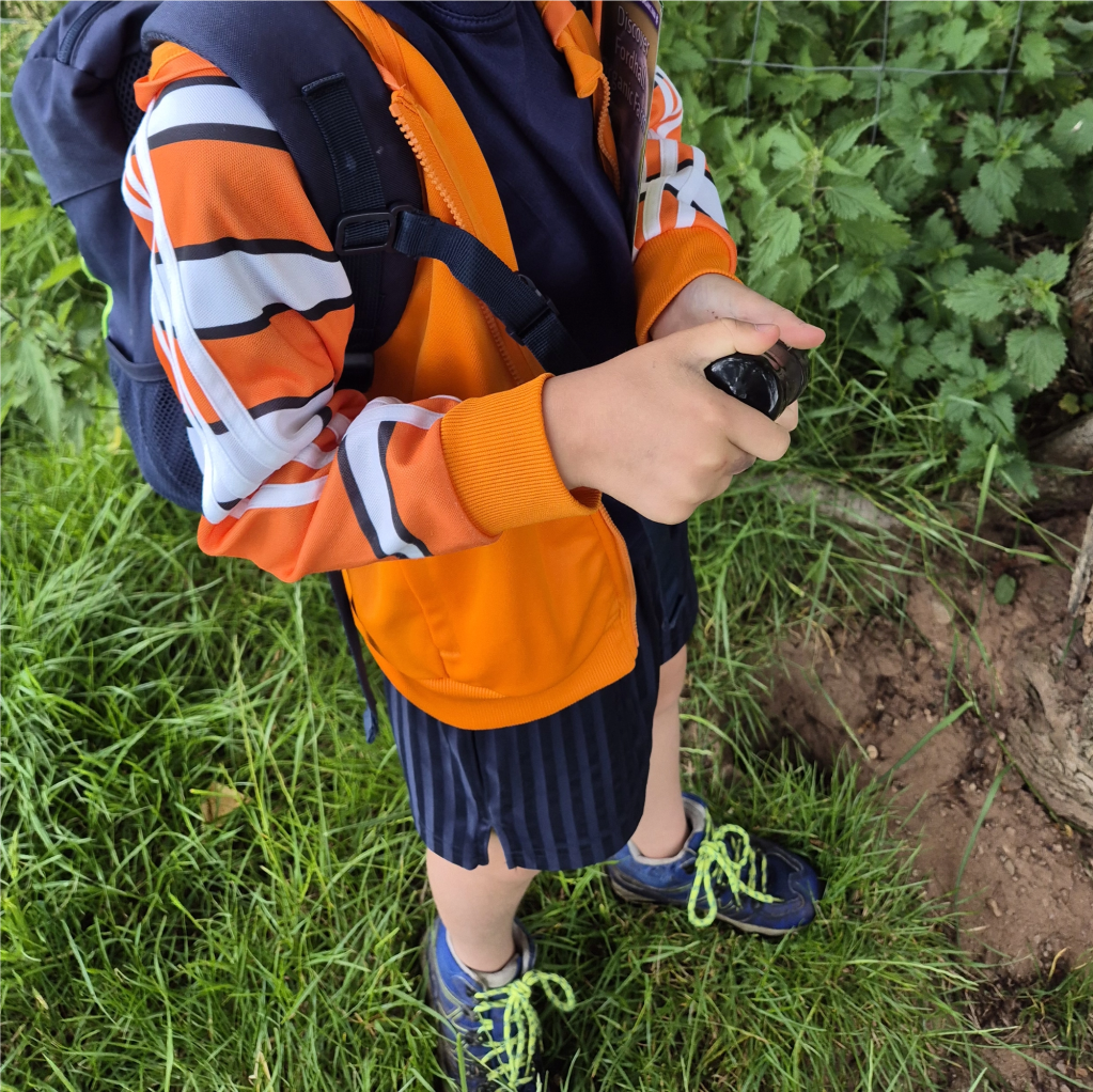 A child holds a small geocache