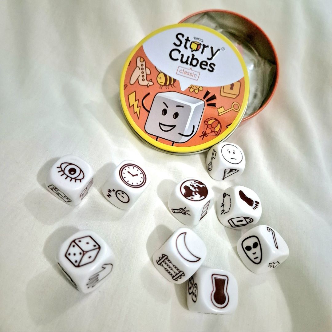 Game dice with pictures of objects in a tin