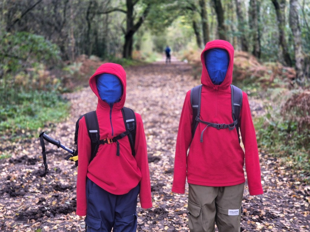 2 boys dress as ninjas on their walk in red hoodies with blue snoods pulled over their heads