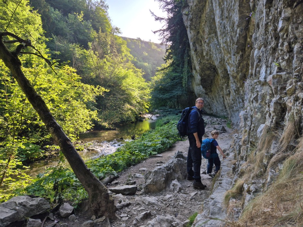 Adult and child climbing rocky terrain through a limestone gorge