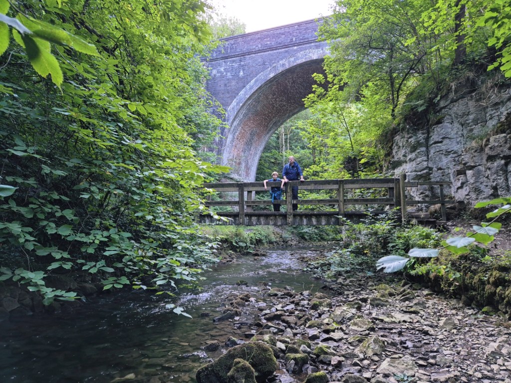 Family walking along a bridge under a viaduct