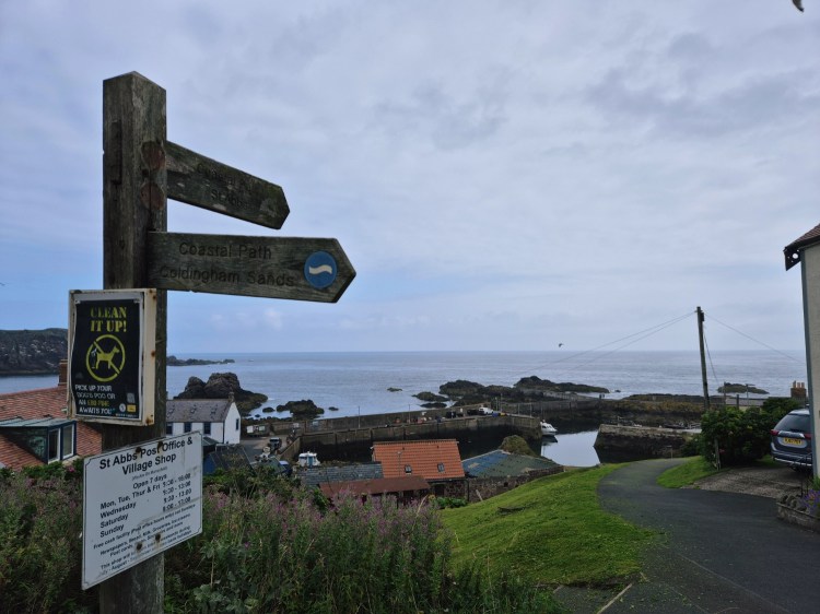 Wooden signpost at the start of a coastal trail near St Abbs harbour.